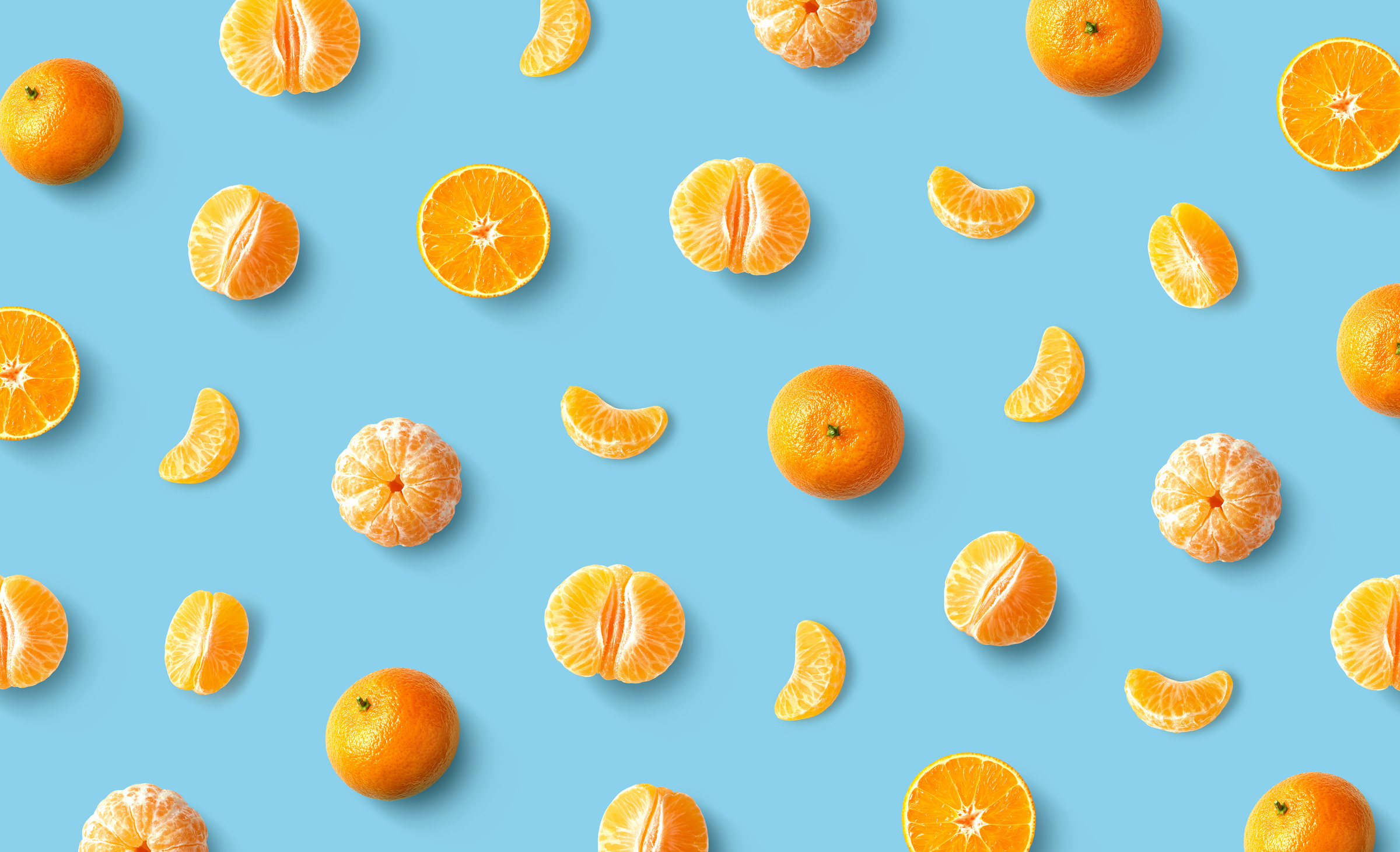 Colorful fruit pattern of fresh mandarin tangerine or clementine on blue background